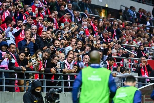 Fans of Reims take picture as Lionel MESSI of PSG is warming up during the Ligue 1 Uber Eats match between Reims and Paris Saint Germain at Stade...