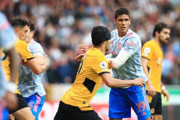 Raphael Varane of Manchester United tussles with Raul Jimenez of Wolverhampton Wanderers during the Premier League match between Wolverhampton...