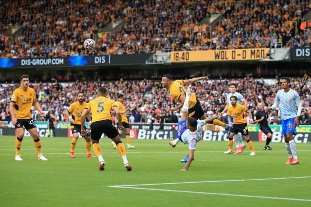 Romain Saiss of Wolverhampton Wanderers clears with a header before Mason Greenwood of Manchester United can connect with an overhead kick during the...