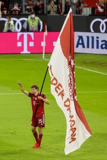 Thomas Mueller of Bayern Muenchen carry a flag after the Bundesliga match between FC Bayern Muenchen and Hertha BSC at Allianz Arena on August 28,...