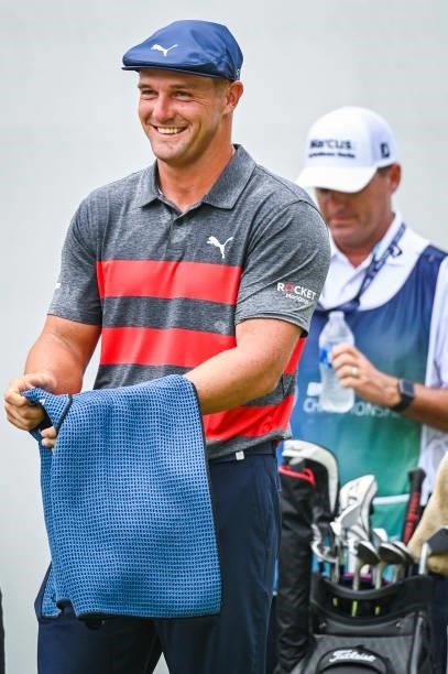 Bryson DeChambeau smiles as he uses a towel to wipe sweat off on the first tee during the final round of the BMW Championship, the second event of...