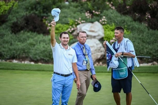 Patrick Cantlay smiles and tips his hat to fans after his victory on the 18th green, the sixth playoff hole, during the final round of the BMW...