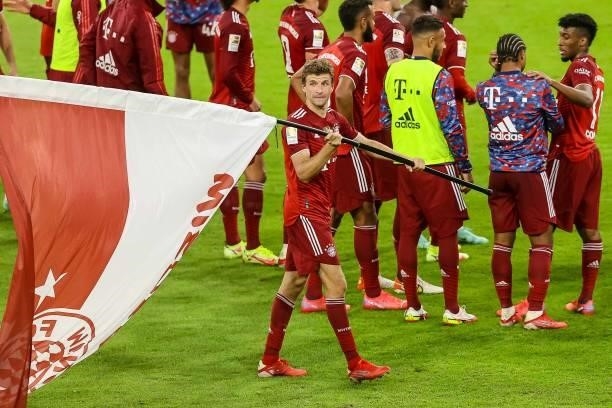 Thomas Mueller of Bayern Muenchen carry a flag after the Bundesliga match between FC Bayern Muenchen and Hertha BSC at Allianz Arena on August 28,...