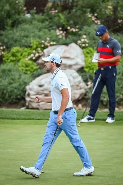 Patrick Cantlay celebrates with a fist pump after making a birdie putt on the sixth playoff hole as Bryson DeChambeau and his caddie Matt Minister...