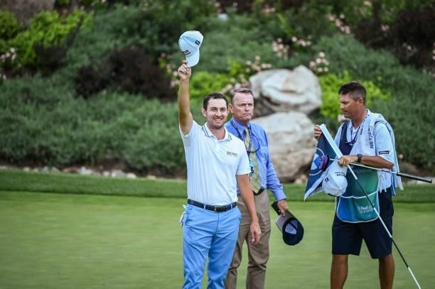 Patrick Cantlay smiles and tips his hat to fans after his victory on the 18th green, the sixth playoff hole, during the final round of the BMW...