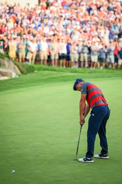 Bryson DeChambeau misses a birdie putt on the 18th hole green as fans watch during a playoff in the final round of the BMW Championship, the second...