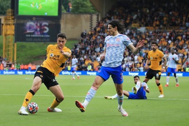Max Kilman of Wolverhampton Wanderers battles with Edinson Cavani of Manchester United during the Premier League match between Wolverhampton...