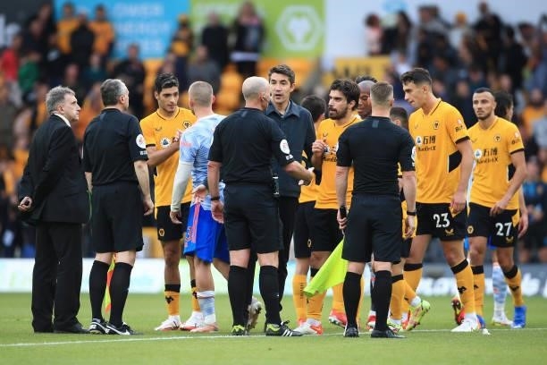 Wolverhampton Wanderers manager Bruno Lage speaks to referee Mike Dean after the Premier League match between Wolverhampton Wanderers and Manchester...