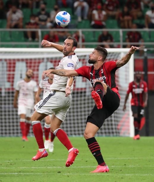 Olivier Giroud of AC Milan competes for the ball with Diego Godin of Cagliari Calcio during the Serie A match between AC Milan and Cagliari Calcio at...