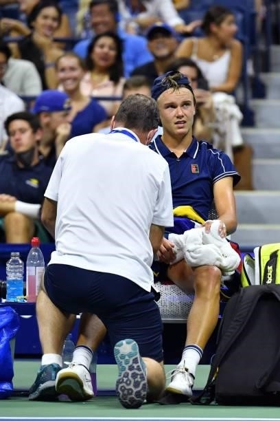 Denmark's Holger Rune receives a leg massage during his 2021 US Open Tennis tournament men's singles first round match against Serbia's Novak...
