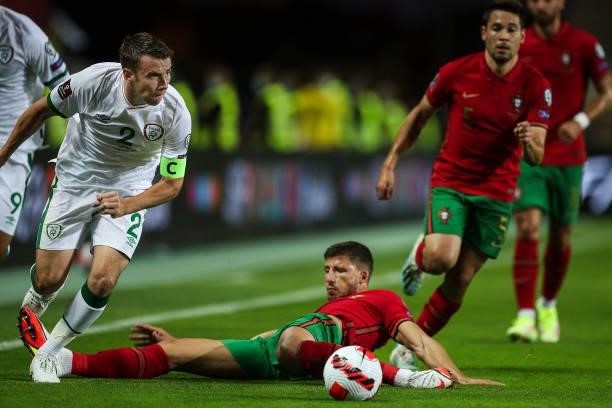 Republic of Ireland's defender Seamus Coleman fights for the ball with Portugal's defender Ruben Dias during the FIFA World Cup Qatar 2022 European...