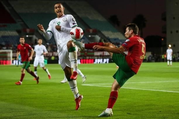 Portugal's defender Raphael Guerreiro fights for the ball with Republic of Ireland's forward Adam Idah during the FIFA World Cup Qatar 2022 European...