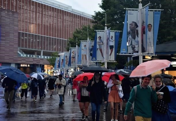 People walk with umbrellas under heavy rain during the 2021 US Open Tennis tournament at the USTA Billie Jean King National Tennis Center in New...