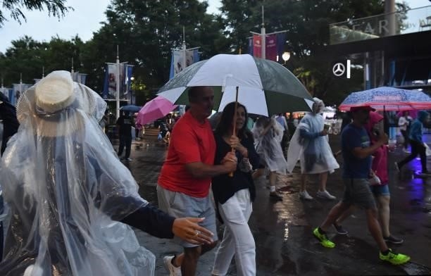 People walk with umbrellas under the rain during the 2021 US Open Tennis tournament at the USTA Billie Jean King National Tennis Center in New York,...