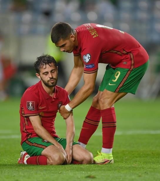 Faro , Portugal - 1 September 2021; Bernardo Silva of Portugal is helped up by team-mate André Silva during the FIFA World Cup 2022 qualifying group...