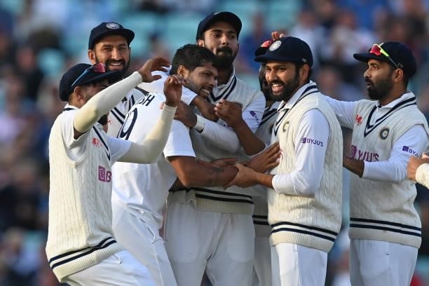 India's Umesh Yadav celebrates with teammates after bowling England's captain Joe Root for 21 runs during play on the first day of the fourth cricket...