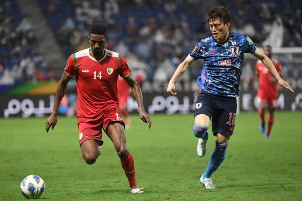 Amjad Al Kharthi of Oman controls the ball against Kyogo Furuhashi of Japan during FIFA World Cup Asian Qualifier Final Round Group B match between...
