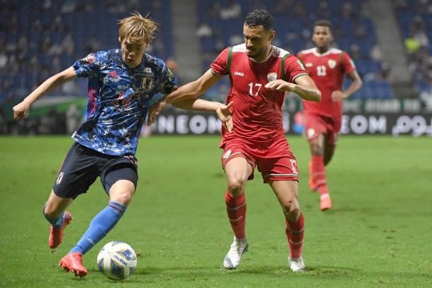 Junya Ito of Japan dribbles the ball under the puressure from Ali Sulaiman Al Busaidi of Oman during FIFA World Cup Asian Qualifier Final Round Group...