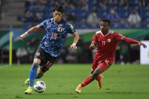 Hiroki Sakai of Japan dribbless the ball under the pressure from Almandhar Al Alawi of Oman during FIFA World Cup Asian Qualifier Final Round Group B...