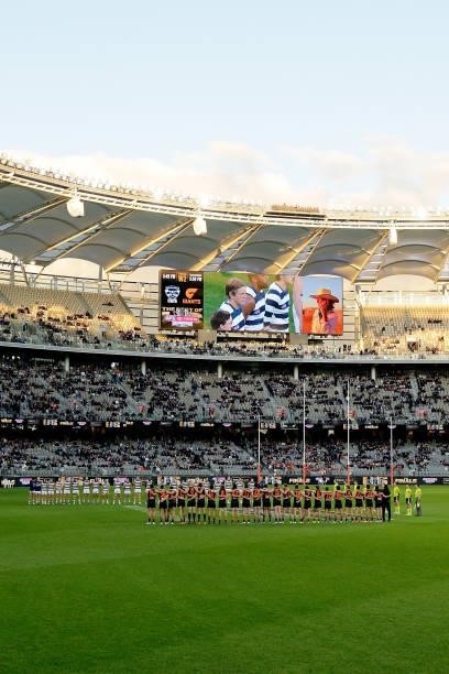 The players line up for the Australian National Anthem during the 2021 AFL Second Semi Final match between the Geelong Cats and the GWS Giants at...