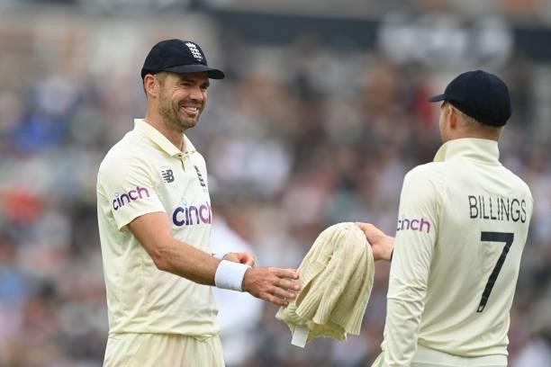 England's James Anderson smiles as he takes back his jumper from England's Sam Billings during play on the third day of the fourth cricket Test match...
