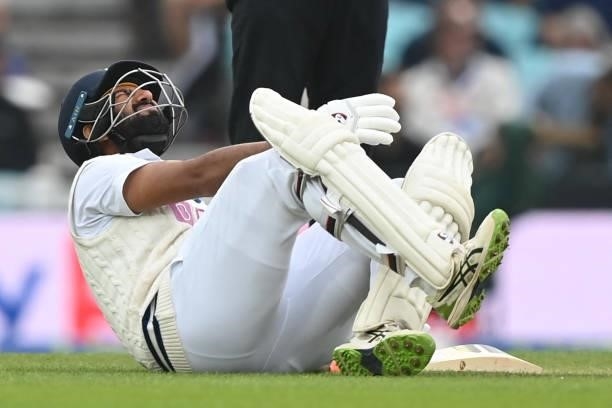 India's Cheteshwar Pujara falls to the ground after twisting his ankle during play on the third day of the fourth cricket Test match between England...