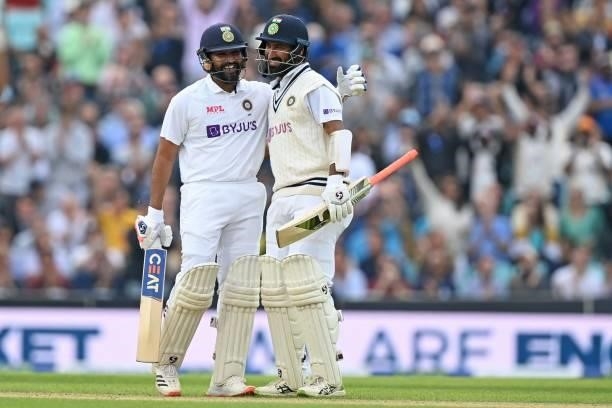 India's Rohit Sharma is congratulated by India's Cheteshwar Pujara after reaching his century during play on the third day of the fourth cricket Test...
