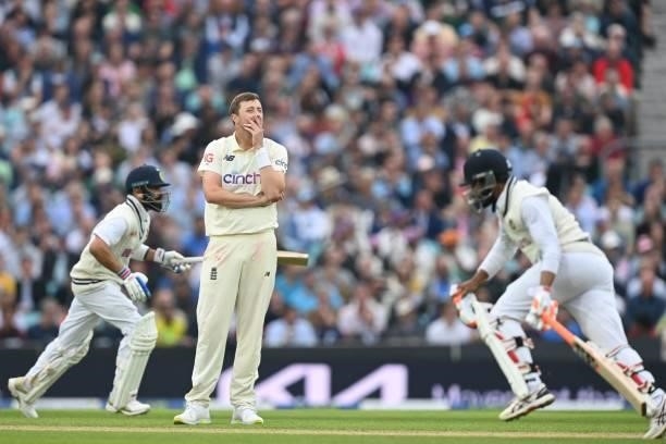 England's Ollie Robinson looks on as India's captain Virat Kohli and India's Ravindra Jadeja take a run during play on the third day of the fourth...