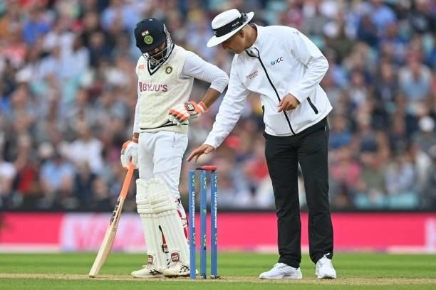 India's Ravindra Jadeja looks on as umpire Michael Gough takes a light reading during play on the third day of the fourth cricket Test match between...