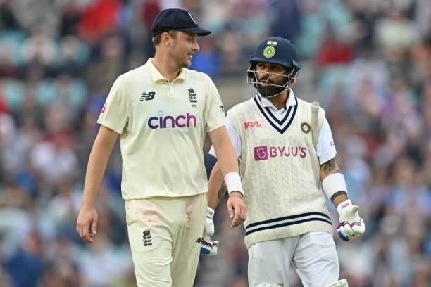 England's Ollie Robinson chats with India's captain Virat Kohli as players leave the field due to bad light during play on the third day of the...