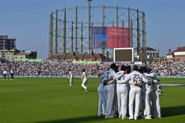 England's openers walk out to begin their second Innings as India's players have a group huddle during play on the fourth day of the fourth cricket...