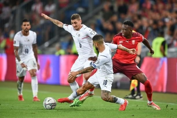 Italy's midfielder Marco Verratti and Italy's forward Lorenzo Insigne fight for the ball with Switzerland's midfielder Denis Zakaria during the World...