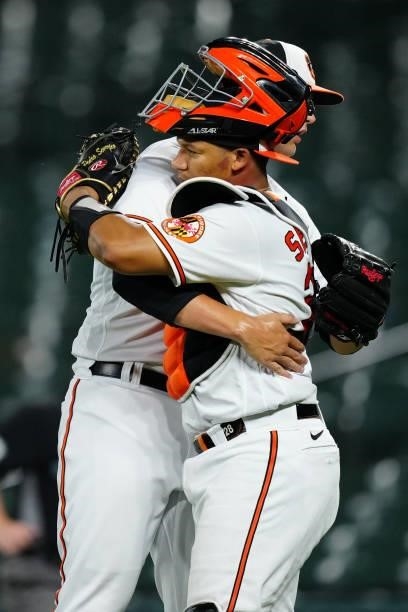Tyler Wells and Pedro Severino of the Baltimore Orioles hug after the Orioles defeat the Kansas City Royals 7-3 at Oriole Park at Camden Yards on...
