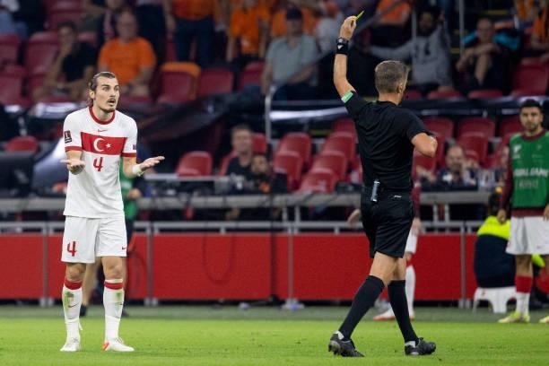 Referee Daniele Orsato shows Caglar Soyuncu of Turkey the yellow card during the 2022 FIFA World Cup Qualifier match between Netherlands and Turkey...