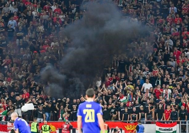 Black smoke rises over the spectators' stands as Hungary's supporters cheer their team during the FIFA World Cup Qatar 2022 qualification Group I...