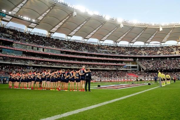 Teams line up for the national anthem during the 2021 AFL First Preliminary Final match between the Melbourne Demons and the Geelong Cats at Optus...