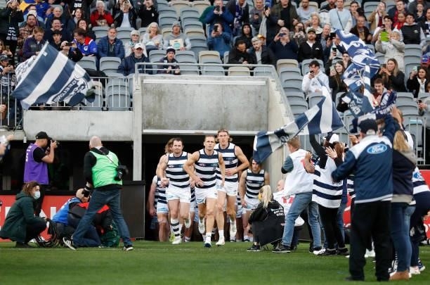 The Cats run onto the field during the 2021 AFL First Preliminary Final match between the Melbourne Demons and the Geelong Cats at Optus Stadium on...