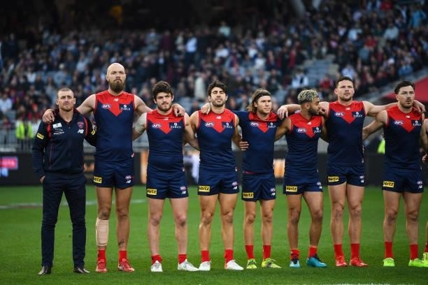 Melbourne line up for the National Anthem during the 2021 AFL First Preliminary Final match between the Melbourne Demons and the Geelong Cats at...