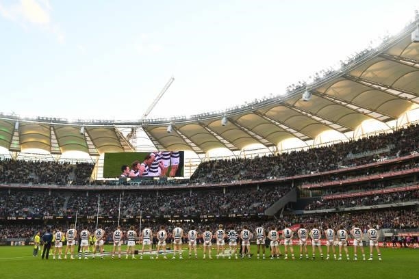 The team line up for the National Anthem during the 2021 AFL First Preliminary Final match between the Melbourne Demons and the Geelong Cats at Optus...