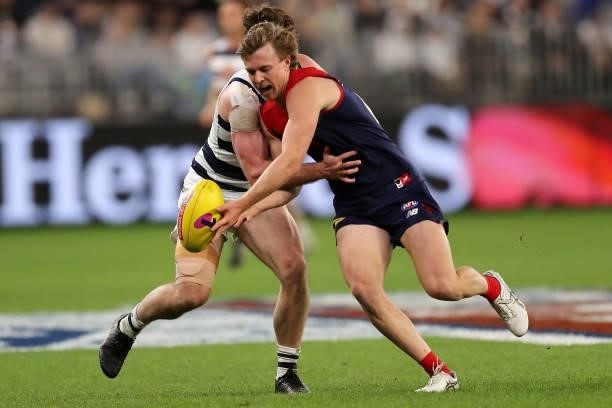 Jed Bews of the Cats and James Jordon of the Demons chase the ball during the 2021 AFL First Preliminary Final match between the Melbourne Demons and...