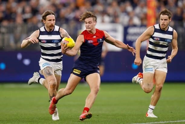 Trent Rivers of the Demons is chased by Zach Tuohy of the Cats during the 2021 AFL First Preliminary Final match between the Melbourne Demons and the...