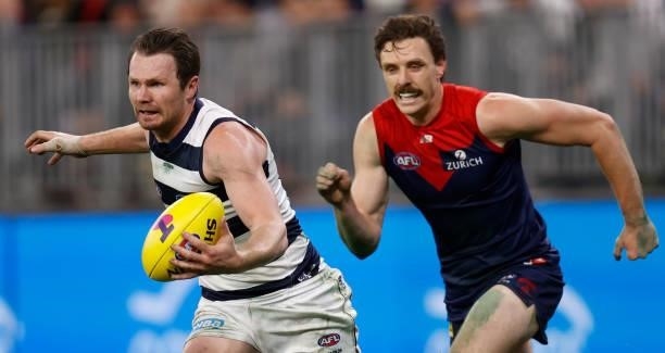 Patrick Dangerfield of the Cats is chased by Jake Lever of the Demons during the 2021 AFL First Preliminary Final match between the Melbourne Demons...