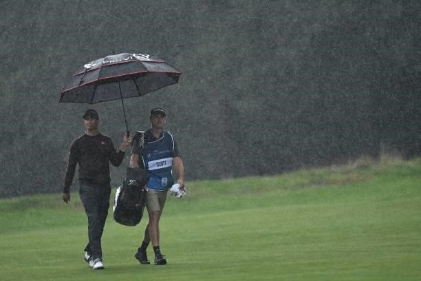 Australia's Adam Scott walks in the rain on the 17th on Day 2 of the PGA Championship at Wentworth Golf Club in Surrey, south west of London on...