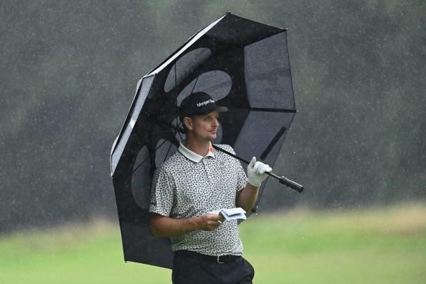 England's Justin Rose shelters under an umbrella on the 17th on Day 2 of the PGA Championship at Wentworth Golf Club in Surrey, south west of London...