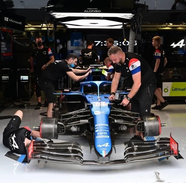 Mechanics work on the car of Alpine's Spanish driver Fernando Alonso prior to a qualifying session at the Autodromo Nazionale circuit in Monza, on...