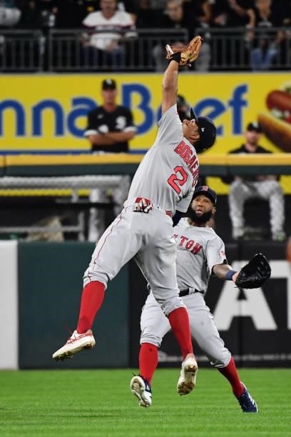 Xander Bogaerts of the Boston Red Sox reaches up to catch a fly ball in short left field as Danny Santana avoids a collision in the fourth inning of...