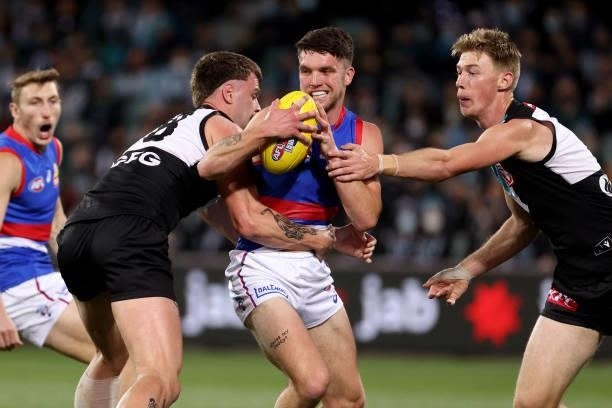 Bailey Williams of the Bulldogs is tackled by Peter Ladhams and Todd Marshall of the Power during the 2021 AFL Second Preliminary Final match between...