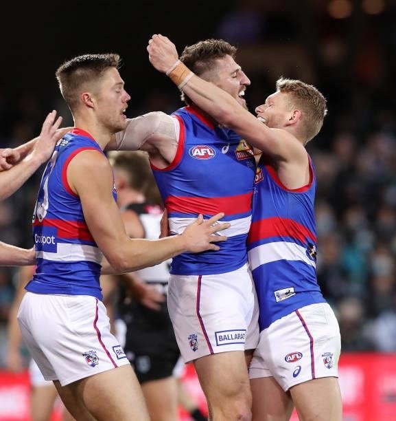 Marcus Bontempelli of the Bulldogs celebrates a goal with Adam Treloar and Josh Schache during the 2021 AFL Second Preliminary Final match between...