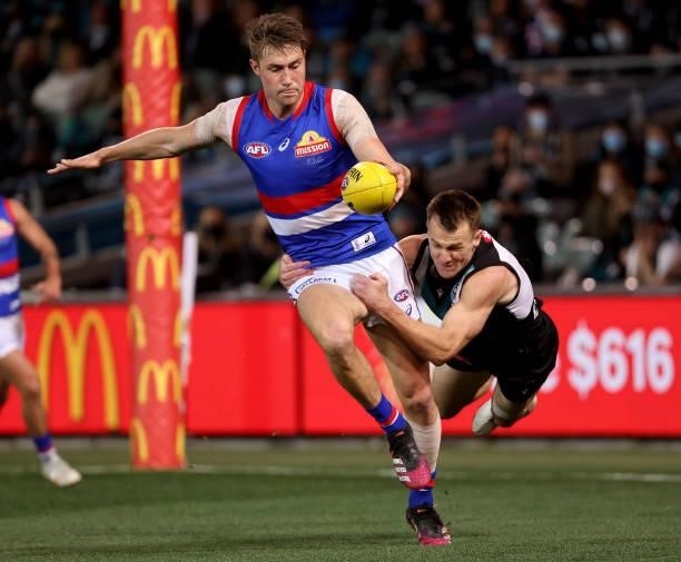 Ryan Gardner of the Bulldogs is tackled by Robbie Gray of the Power during the 2021 AFL Second Preliminary Final match between the Port Adelaide...