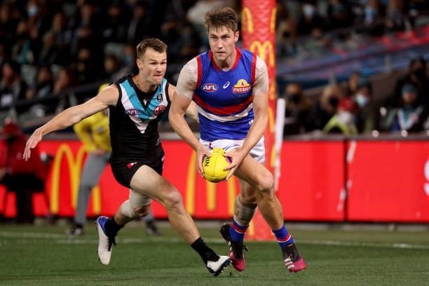 Ryan Gardner of the Bulldogs is tackled by Robbie Gray of the Power during the 2021 AFL Second Preliminary Final match between the Port Adelaide...